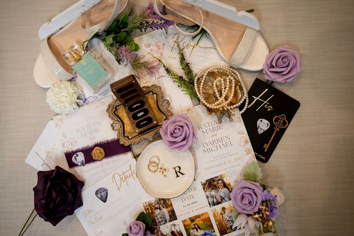 Wedding invitation suite, rings, perfume, shoes, and purple floral details arranged as a bridal flat lay.