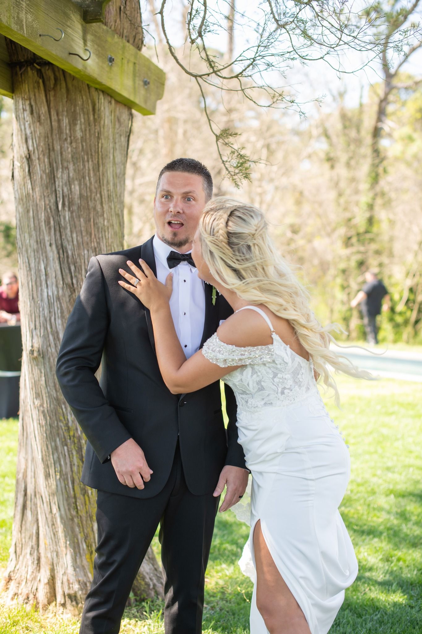 Groom smiling in surprise as he sees his bride during their outdoor first look.