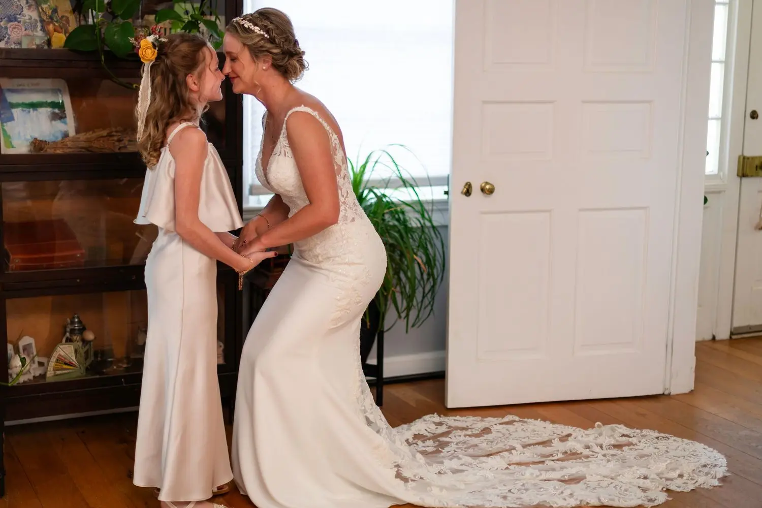 Two brides holding hands and smiling together during a quiet moment on their wedding day.